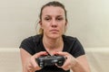 A young woman plays a game console with a joystick