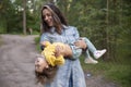 Young woman plays with toddler girl in yellow in park Royalty Free Stock Photo