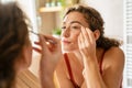 Young woman plucking eyebrows with tweezers Royalty Free Stock Photo