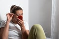 Young woman plucking eyebrows with tweezers using makeup mirror to see herself. Girl`s face while she is removing her facial hairs Royalty Free Stock Photo