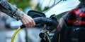 Young woman plugs charging gun in her electric car comeliness