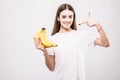 Young beauty woman pointed on bananas on white background. Health concept.