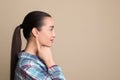 Young woman pointing at her ear on beige background. Space for text Royalty Free Stock Photo