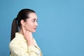 Young woman pointing at her ear on light blue background. Space for text Royalty Free Stock Photo