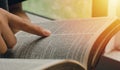 A young woman pointing out the verses of the Scriptures that are true to life while reading the bible In the morning by the Royalty Free Stock Photo