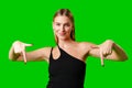 Young Woman Pointing at Something against green background