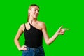 Young Woman Pointing at Something against green background