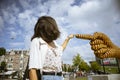 Young woman points the finger the sculpture of a yellow hand, in Museumplein, Museums Square Royalty Free Stock Photo