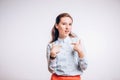 Young woman points at herself with a questioning face on white background. Royalty Free Stock Photo