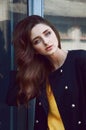 Young woman portrait in black trenchcoat and yellow blouse