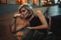 Young woman portrait lying on wet pavement on city street in eve Royalty Free Stock Photo