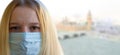 Young woman portrait with medical mask, blurred London city background. Concept covid-19 prevention coronavirus pandemic