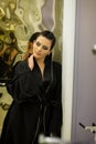 Young woman posing in black silk bathrobe. sexy housewife concept. Girl in a black bathrobe indoors. Beauty saloon Royalty Free Stock Photo