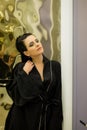 Young woman posing in black silk bathrobe. sexy housewife concept. Girl in a black bathrobe indoors. Beauty saloon Royalty Free Stock Photo