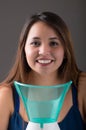 Young woman posing for camera behind of a medical vaporizer nebulizer machine on grey background