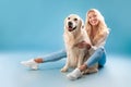 Young woman posing with her dog at blue studio Royalty Free Stock Photo