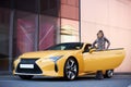 Young woman posing near the supercar, outdoors portrait Royalty Free Stock Photo