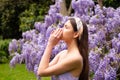 Young woman posing on a park background. Sneezing young girl with nose wiper among blooming trees in park. Pollen Royalty Free Stock Photo