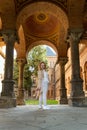 Young woman posing for photo in the arch of historic building. Full-length portrait of girl looking over her shoulder Royalty Free Stock Photo