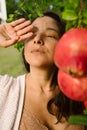 Young woman posing with ripe red pomegranates tree. concept of healthy autumn and winter lifestyle and diet, outdoors with nature