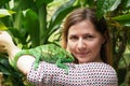 Young woman posing with small green Parson\'s chameleon walking on her hand, jungle leaves background Royalty Free Stock Photo