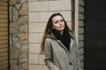 Young woman posing on the street in a brown cardigan