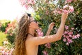 Young woman posing in swimming suite against bushes with pink roses. Royalty Free Stock Photo