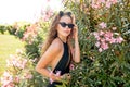 Young woman posing in swimming suite against bushes with pink roses. Royalty Free Stock Photo