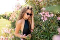 Young woman posing in swimming suite against bushes with pink roses. Royalty Free Stock Photo