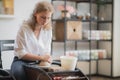 Young woman potter in apron at work. Craftsman artist shapes the jug with her hands and a special tool on pottery wheel. Royalty Free Stock Photo