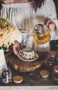 Young woman pouring green tea from glass pot into cup Royalty Free Stock Photo