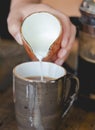 Young woman pouring milk into cup of filtered coffee Royalty Free Stock Photo