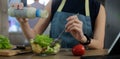 Young woman pouring salad dressing on salad in a glass bowl. Concept of healthy eating Royalty Free Stock Photo