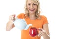 Young Woman Pouring Tea from a Teapot Royalty Free Stock Photo