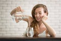 Young woman pouring water from jug into glass Royalty Free Stock Photo