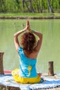 Young woman practice yoga outdoor by the lake healthy lifestyle concept back view full body shot Royalty Free Stock Photo