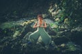 Young woman practice yoga outdoor in riverbed of small mountain