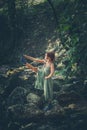 Young woman practice yoga outdoor in riverbed of small mountain