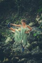 Young woman practice yoga outdoor in riverbed of small mountain