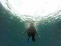 Young woman practices the sport scuba diving with oxygen tank equipment, visor, fins, relaxes and enjoys the bottom of the crystal Royalty Free Stock Photo