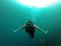 Young woman practices the sport scuba diving with oxygen tank equipment, visor, fins, relaxes and enjoys the bottom of the crystal Royalty Free Stock Photo