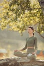 Young woman practices yoga and meditates in nature Royalty Free Stock Photo