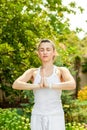 Young woman practices yoga in the summer garden -Namaskar Mudra