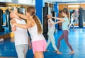 Young woman practicing palm heel strike to man in self-defense training in gym Royalty Free Stock Photo