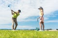 Young woman practicing the correct move during golf class with a