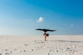 Young woman practicing handstand on beach with white sand and bright blue sky Royalty Free Stock Photo