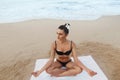 Young woman practicing morning meditation in nature at the beach. Beautiful girl doing yoga. Royalty Free Stock Photo