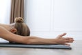 Young woman practicing restorative asana pose in yoga studio, closeup