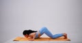 Young woman practicing surya namaskara yoga pose