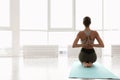 Young woman practicing thunderbolt asana with reverse prayer arms in yoga studio. Vajrasana Paschima Namaskarasana pose Royalty Free Stock Photo